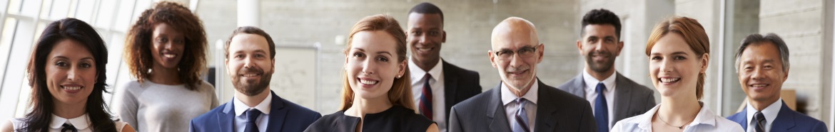 Image of 9 smiling people who are professionally dressed and standing in an office environment.